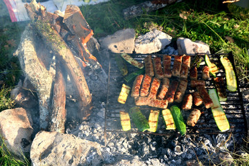Kebab meat and zucchini on an outdoor barbecue. Picnic in nature. Selective focus.