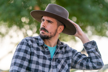 Naklejka na ściany i meble Cowboy with grey hat, moustache and checkerboard shirt