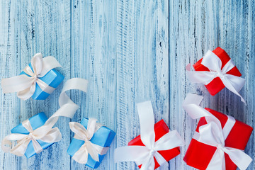 Christmas gifts packed with ribbons on wooden background