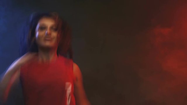girl dancing zumba fitness workout in a studio with red and blue fog