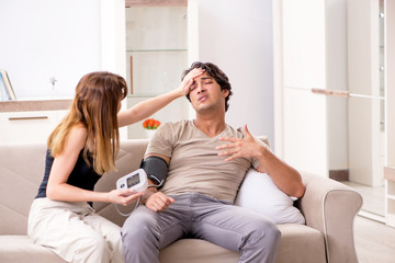 Wife checking husband's blood pressure 