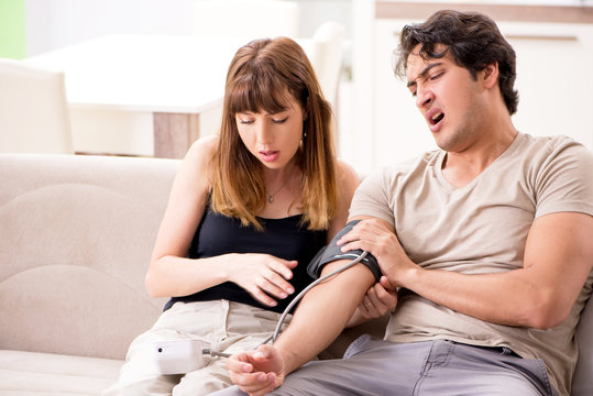 Wife checking husband's blood pressure 