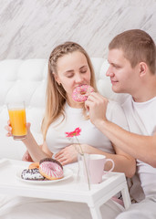 Obraz na płótnie Canvas Romantic happy couple having breakfast in bed