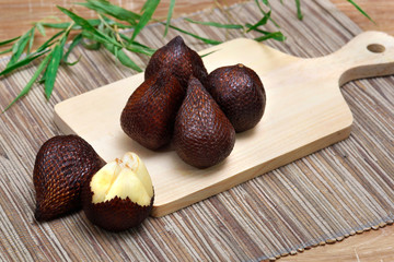 salak fruit  ( salacca zalacca) in wooden plate onwood texture background