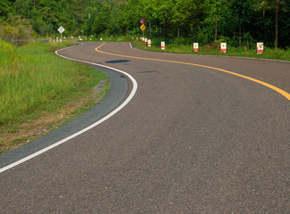 Winding road in mountain. Summer day road trip. Serpentine road perspective photo. New asphalt road curve.