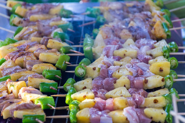 BBQ sticks grilling on fire with smoke