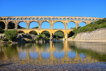 Aqueduct Pont du Gard reflected in Gardon River, southern France