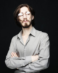 Young man wearing eyeglasses over black background. Lifestyle co