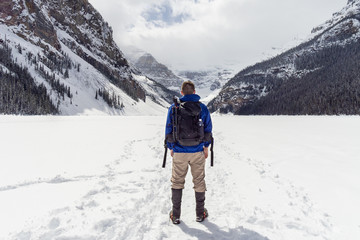 Fototapeta na wymiar Hiker Standing on Frozen Alpine Lake