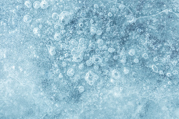 Texture of ice block surface with cracks, bubble patterns and scratches, macro view
