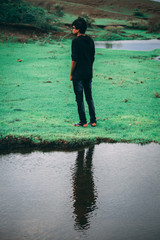 Naklejka premium Reflection of man in water of the lake