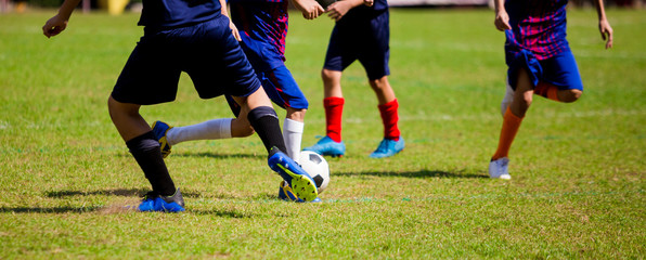 Kid soccer players run to trap and control the ball for shoot to goal