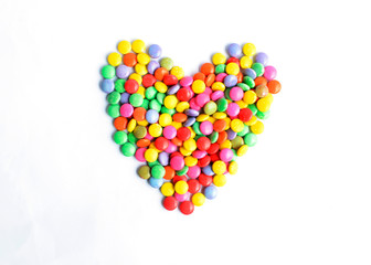 Heart shaped a pile of colorful chocolate coated candy Isolated on white backgrounds