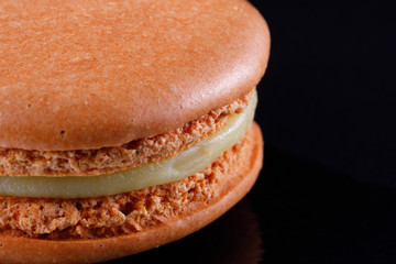 Bright juicy delicious macarons of delicate color on a black background.