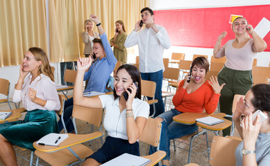 Excited student group talking on phones