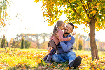 Fototapeta premium happy dad with daughter at sunset walking in the park in autumn