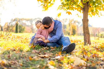 happy dad with daughter at sunset walking in the park in autumn