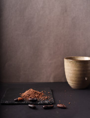 Cocoa beans and cacao powder on dark background