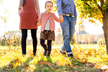 happy family at sunset walking in the park in autumn