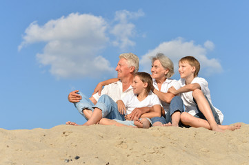 Portrait of grandparents with their grandchildren on the sand