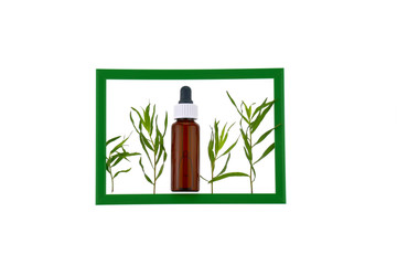 Tarragon essential oil in a bottle of dark glass with a pipette and fresh green twigs of tarragon...