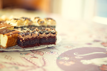 Platter with homemade cakes on a table covered with a tablecloth.