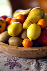 Table covered with a tablecloth and fruit on dishes in it. Shallow depth of field.