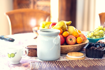 Table covered with a tablecloth and fruit on dishes in it. Shallow depth of field.