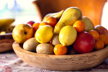 Table covered with a tablecloth and fruit on dishes in it. Shallow depth of field.