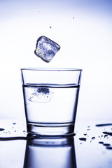 Splash ice cubes in a water glass