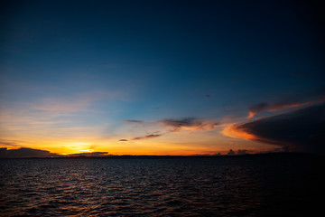 Colorful sunrise with blue sky, orange clouds and rippled sea. Orange blue skyscape in early morning.