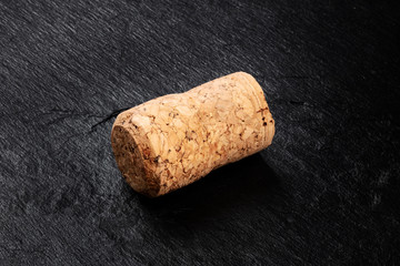 A closeup photo of a champagne cork on a black background with a place for text