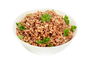 Cooked buckwheat in a bowl, garnished with fresh parsley, isolated on a white background with a clipping path