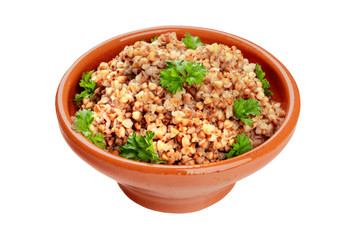 Cooked buckwheat in a rustic earthenware bowl, garnished with fresh parsley leaves, isolated on a white background with a clipping path