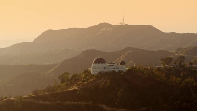 Cinematic Aerial of Griffith Observatory with  The Hollywood  Sign as background / Los Angeles, California 