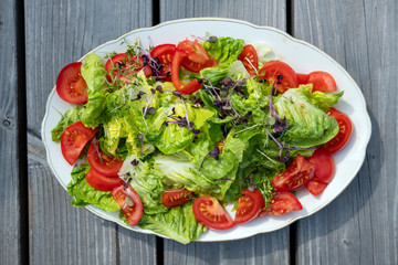 mixed summer salad on wooden ground