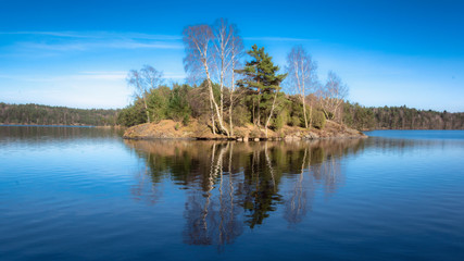 Fototapeta premium A small island which is reflected in a local lake sweden gothenburg