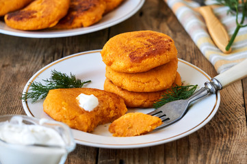 Carrot cutlets with sour cream and fresh dill on a plate 