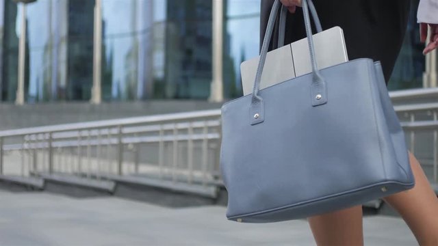 close-up business woman carrying bag with laptop