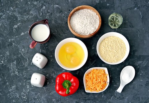 Ingredients for cooking corn unleavened bread: wheat flour, red peppers, corn flour, oil, salt, pepper, grated cheddar cheese, baking powder, eggs, milk or buttermilk.