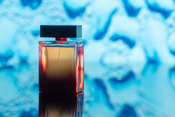 The bottle of perfume on abstract blue background