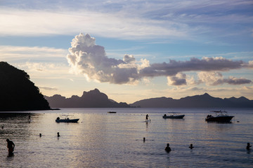 Sunset landscape on tropical island. Sea view with distant mountain and cloud. Beautiful beach Los Cabanos in EL Nido