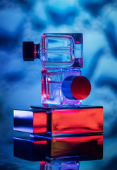 Three bottles of perfume lying on top of each other