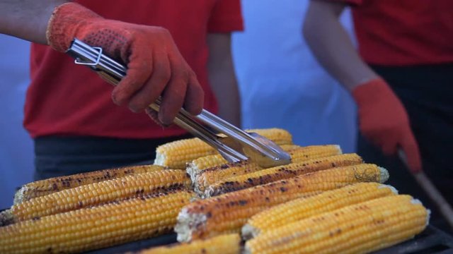 Close up of appetizing grilled sweet corn on the bbq grill. Street food festival.
