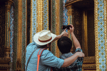 Traveling Asian with backpack look searching direction on location map at Wat Phra Kaeo. Ancient and historical attractions of Bangkok province thailand. Travel, Tourist Concept