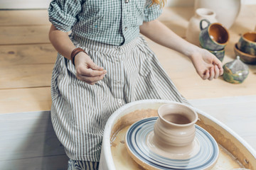 ready handmade pottery. woman has finished to make a pot. good job. smll business concept