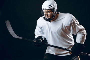 Hockey defensive player in white sports uniform holding hockey stick prepare to defense against...