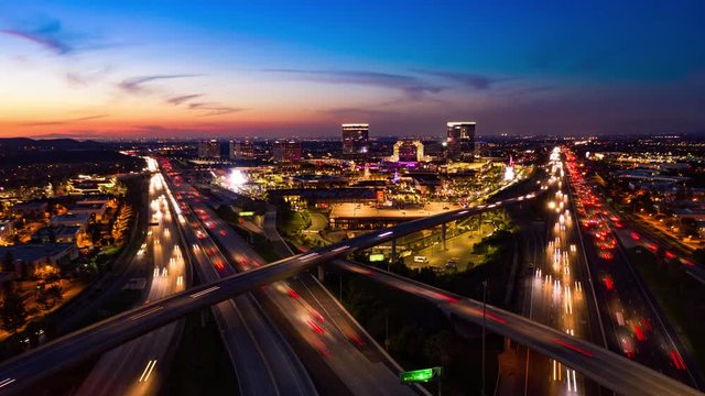 Aerial time lapse in motion drone shot of freeway and interstate traffic after sunset at night.