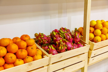 Pitaya or the fruit of the dragon lie in a wooden box in the store on the shelf.