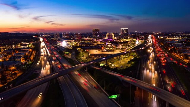 Aerial hyperlapse drone shot of fast moving freeway traffic at night showing cars with light streaks